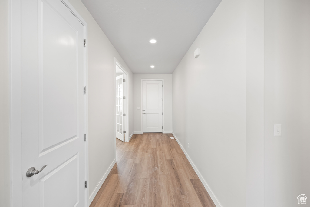 Hall with light wood-style floors, baseboards, and recessed lighting
