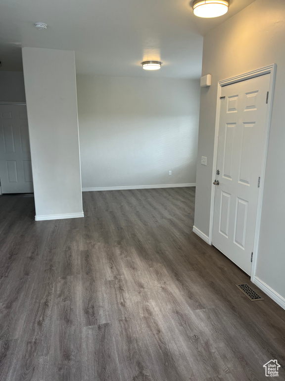 Foyer entrance featuring dark wood-style flooring and baseboards
