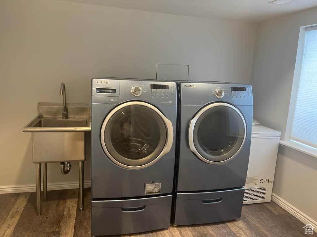 Laundry area featuring washer and dryer, wood finished floors, and baseboards