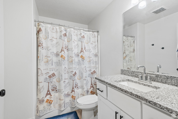 Full bath with vanity, toilet, and a shower with shower curtain