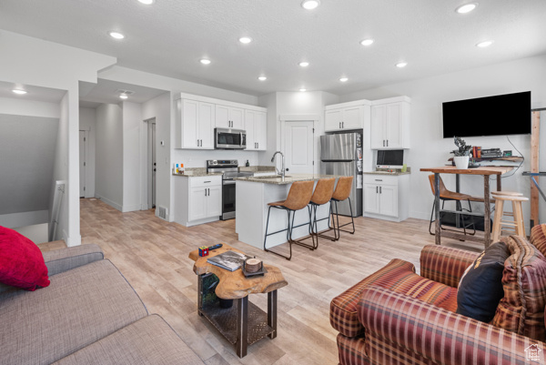 Living room featuring recessed lighting, light wood finished floors, and baseboards