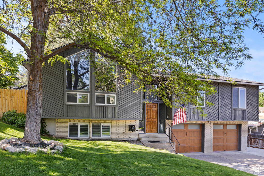 View of front of property with brick siding, driveway, and a garage
