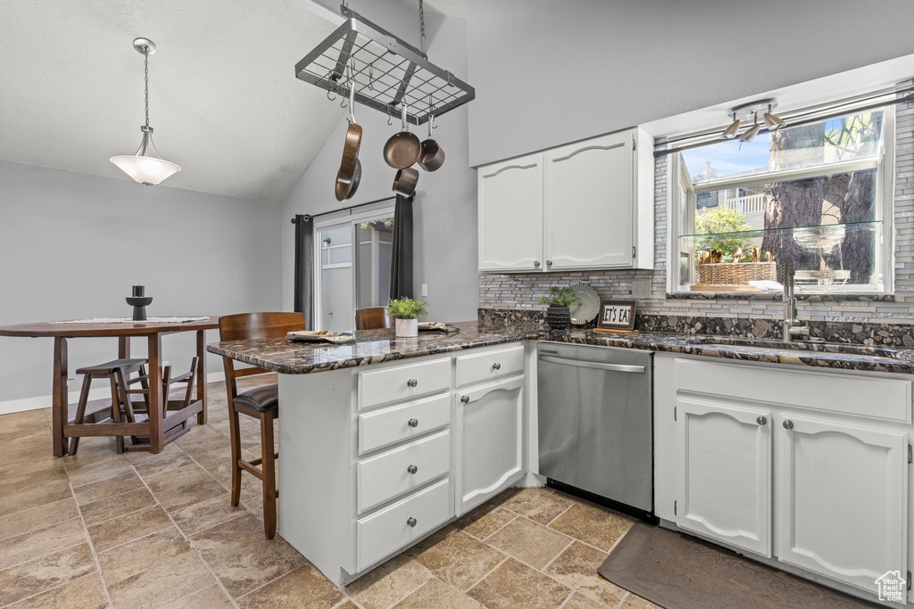 Kitchen featuring dishwasher, a peninsula, a sink, white cabinets, and light stone finish floors