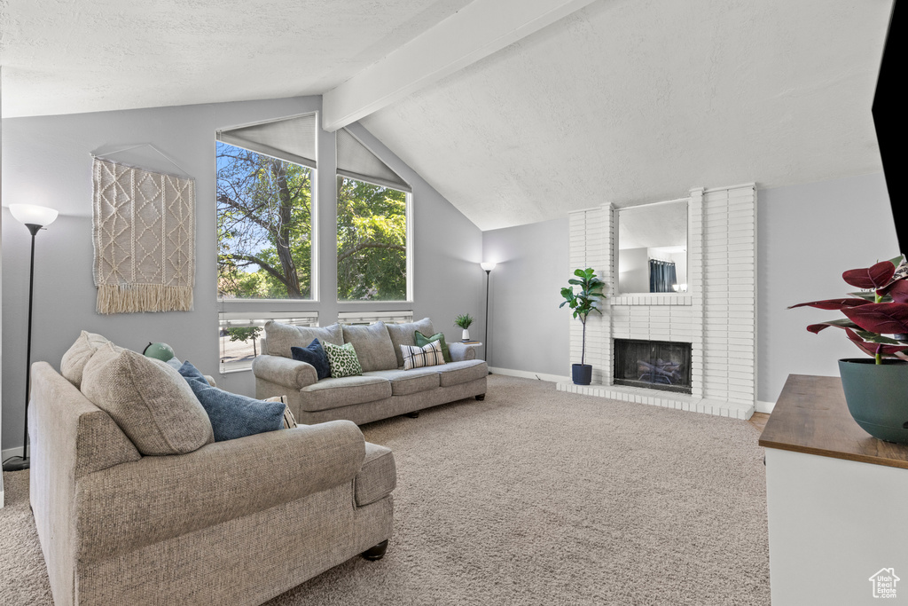 Carpeted living area with baseboards, a brick fireplace, and a textured ceiling