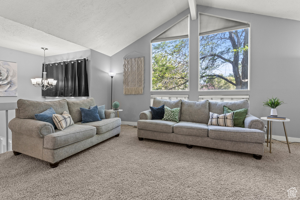 Carpeted living area with a chandelier, baseboards, and vaulted ceiling