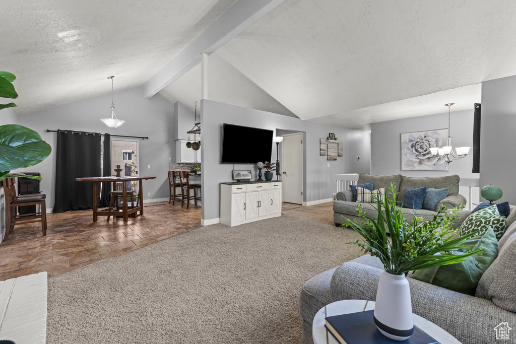 Carpeted living area featuring a chandelier, baseboards, and a textured ceiling