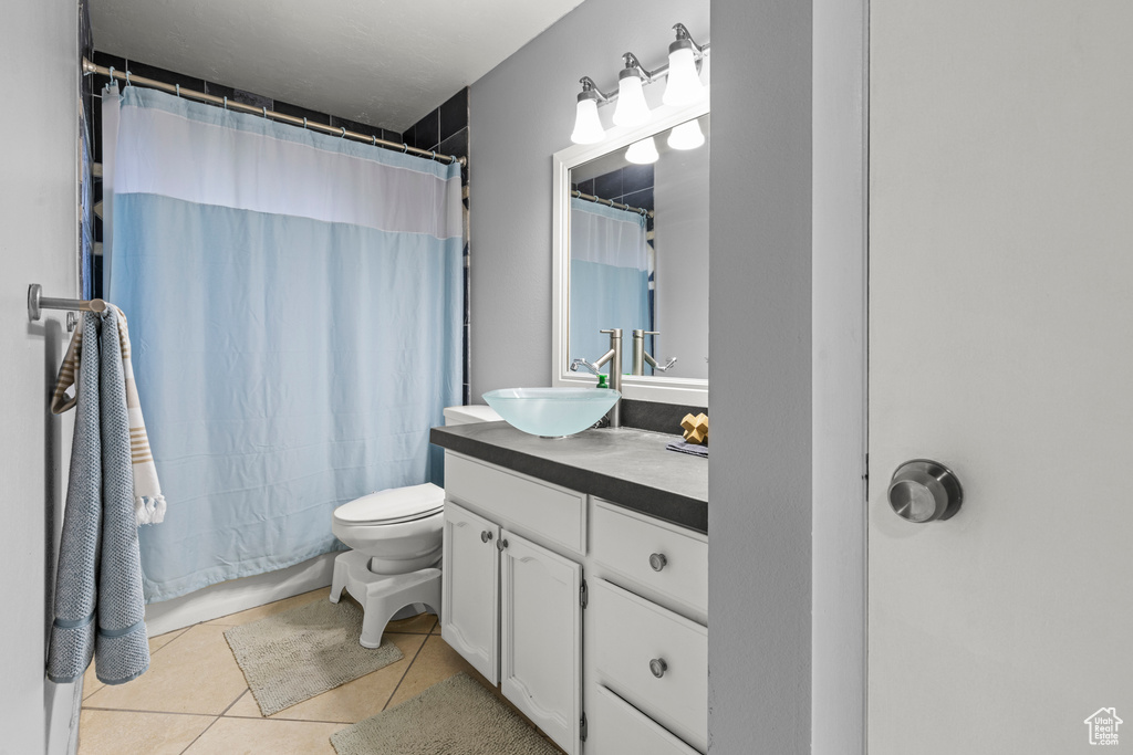 Bathroom featuring vanity, toilet, tile patterned flooring, and shower / bath combo