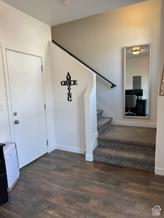 Stairs with wood finished floors and baseboards