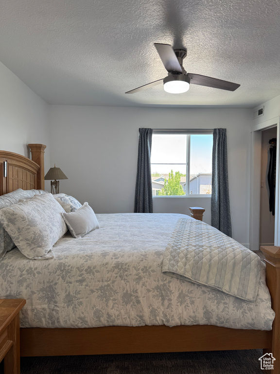 Bedroom with a textured ceiling and a ceiling fan