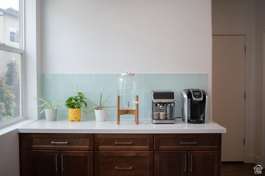 Kitchen featuring tasteful backsplash, light countertops, and dark brown cabinets