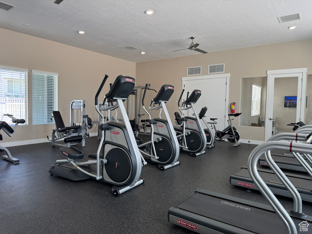 Gym featuring a textured ceiling, recessed lighting, baseboards, and ceiling fan