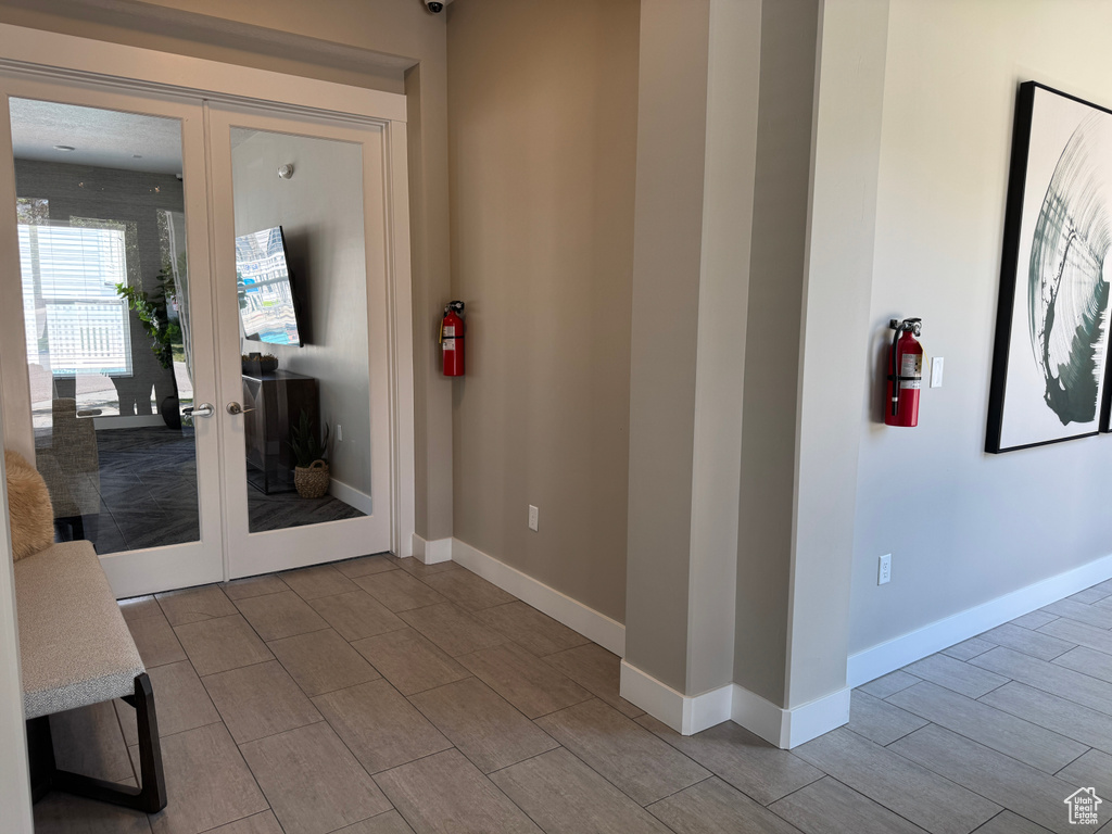 Entryway featuring french doors, wood tiled floors, and baseboards