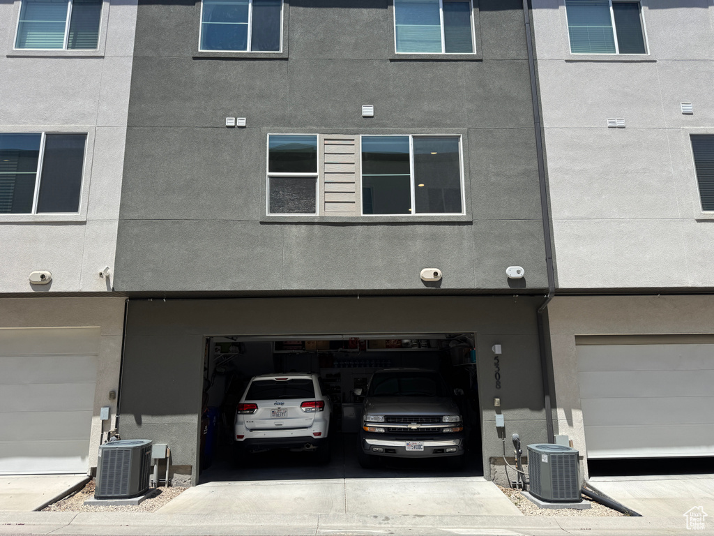 View of building exterior featuring central air condition unit and an attached garage