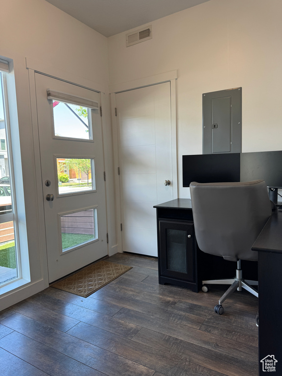 Home office with electric panel and dark wood-style floors