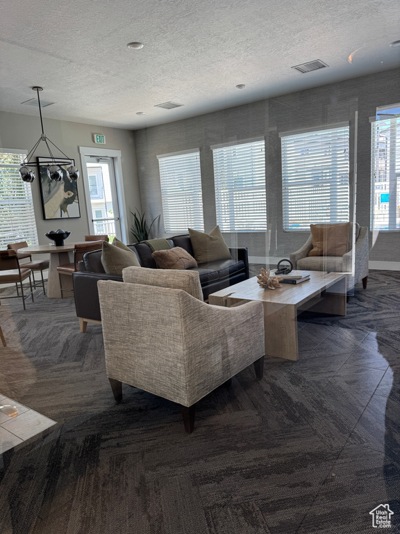 Living area featuring a textured ceiling and a chandelier