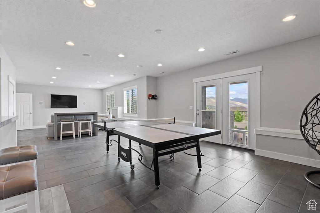 Recreation room featuring recessed lighting, french doors, baseboards, and a textured ceiling