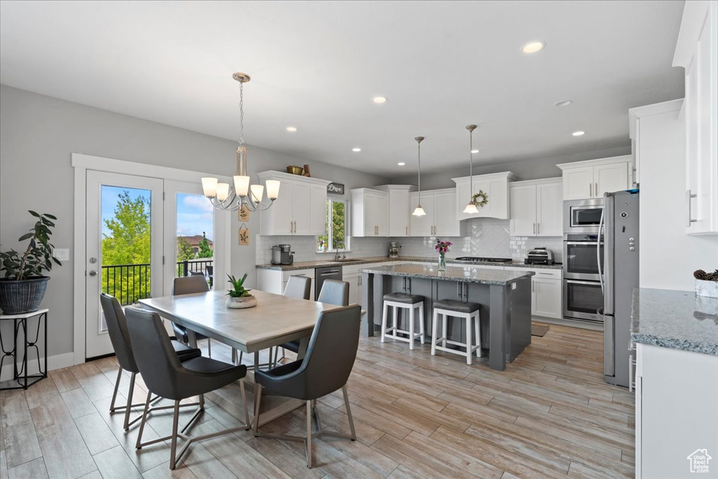 Dining room featuring a chandelier, light wood-type flooring, and recessed lighting