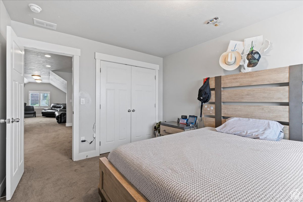 Carpeted bedroom with a closet and baseboards