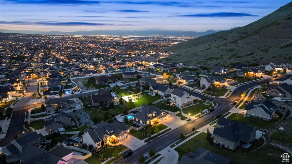 Aerial view of property and surrounding area featuring nearby suburban area and mountains