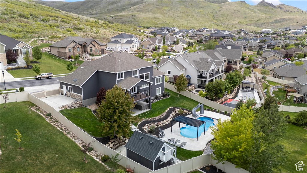 Aerial perspective of suburban area with a mountainous background and a pool