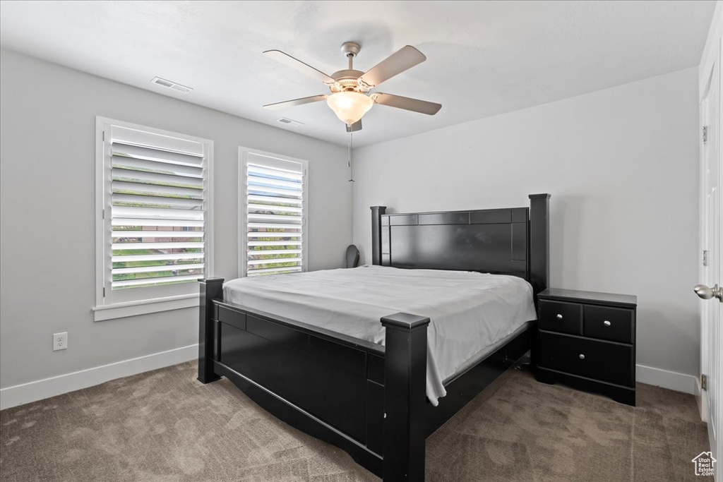 Bedroom with carpet floors, baseboards, and ceiling fan