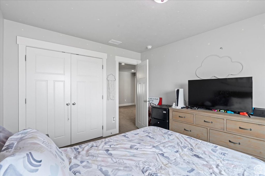 Bedroom featuring carpet flooring, baseboards, and a closet