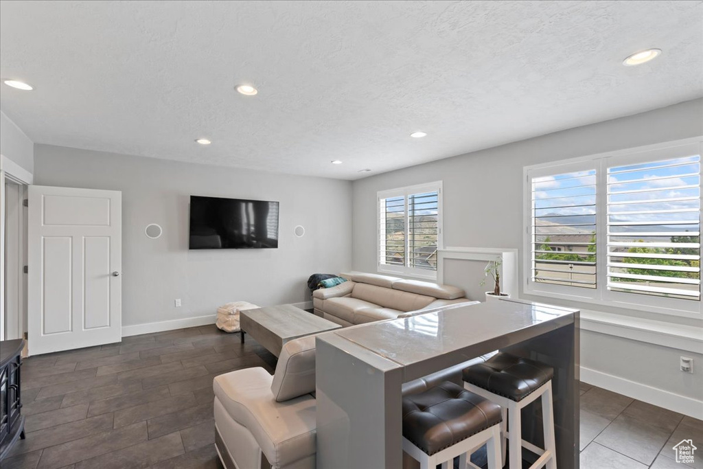 Living room featuring baseboards, recessed lighting, and a textured ceiling