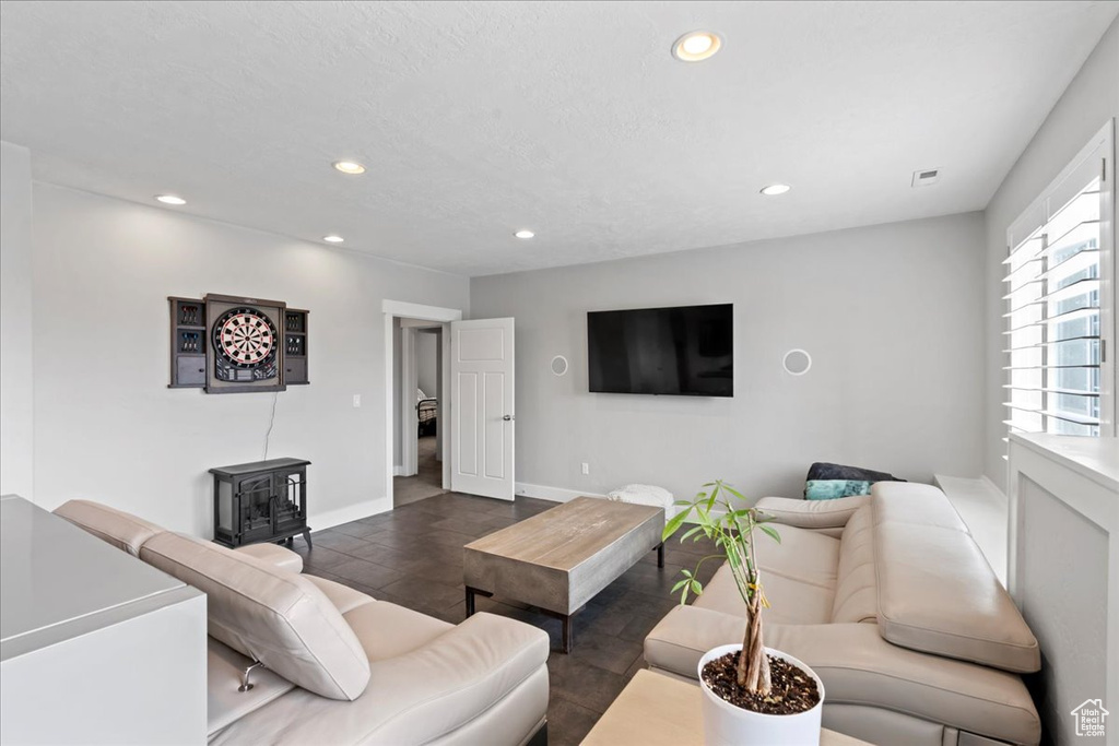 Living area with a wood stove, recessed lighting, and baseboards