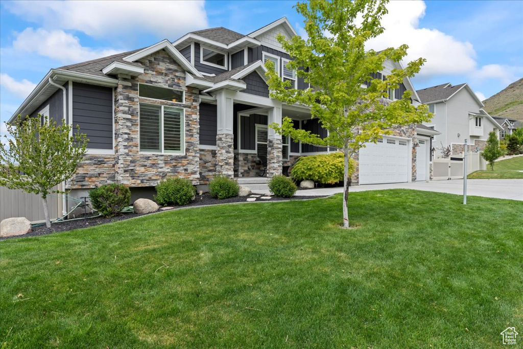 Craftsman inspired home with concrete driveway and stone siding