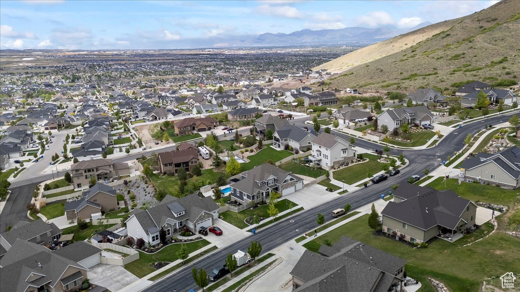Aerial view of property and surrounding area featuring nearby suburban area and a mountain backdrop