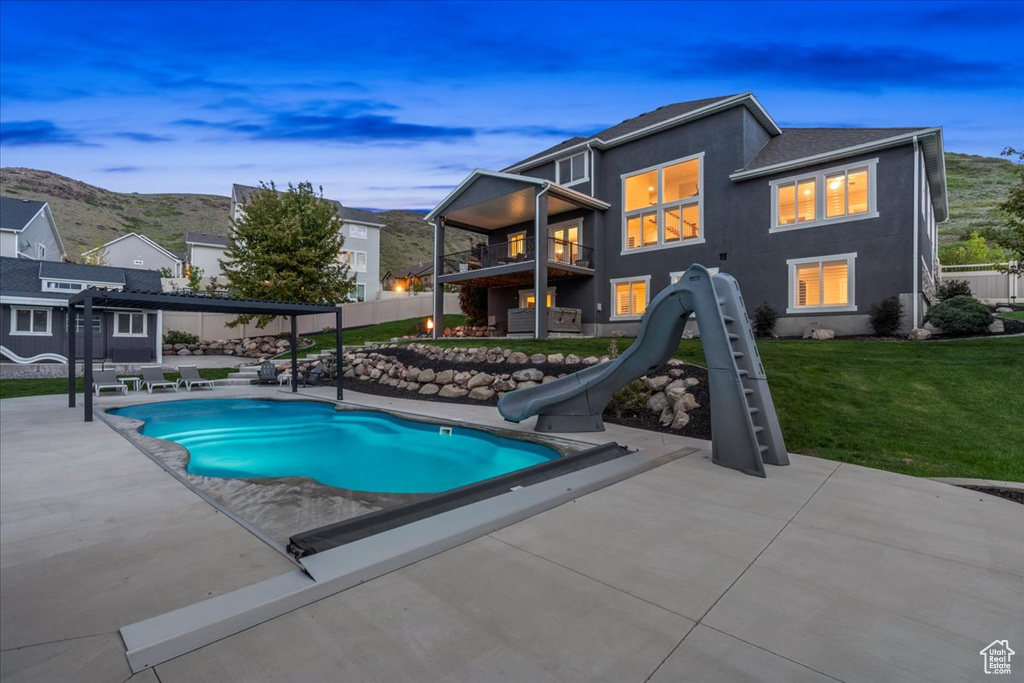 View of swimming pool featuring a water slide and a patio area