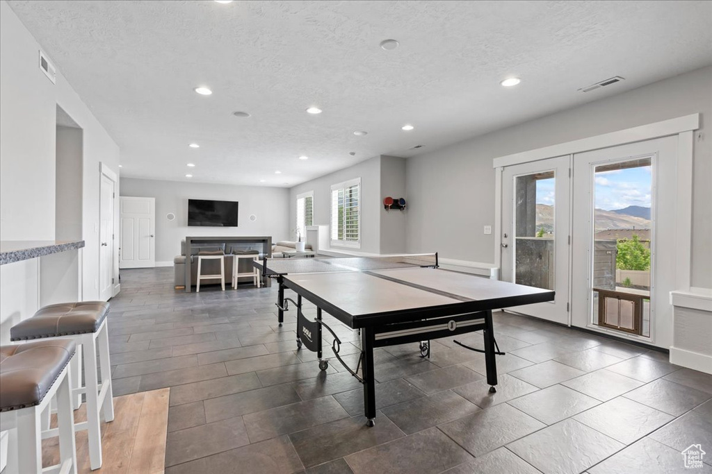 Game room featuring recessed lighting, a textured ceiling, french doors, and baseboards