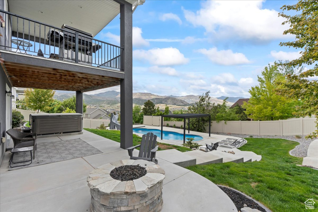 View of patio with a fire pit and a mountain view