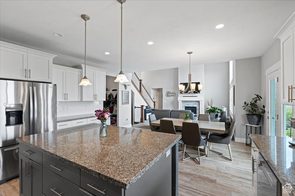 Kitchen with stainless steel appliances, tasteful backsplash, recessed lighting, white cabinets, and a kitchen island