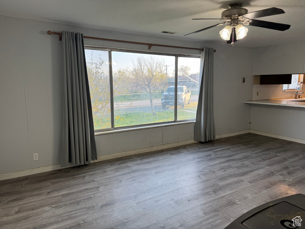 Unfurnished dining area featuring ceiling fan, wood finished floors, and healthy amount of natural light