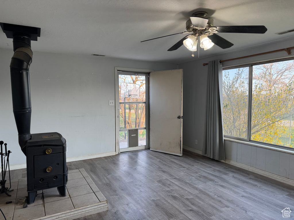 Unfurnished living room featuring wood finished floors, ceiling fan, and baseboards