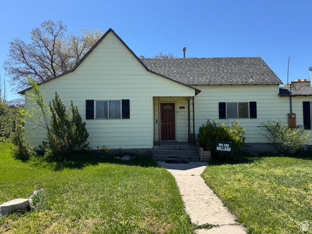 Bungalow-style house with a front yard and a shingled roof