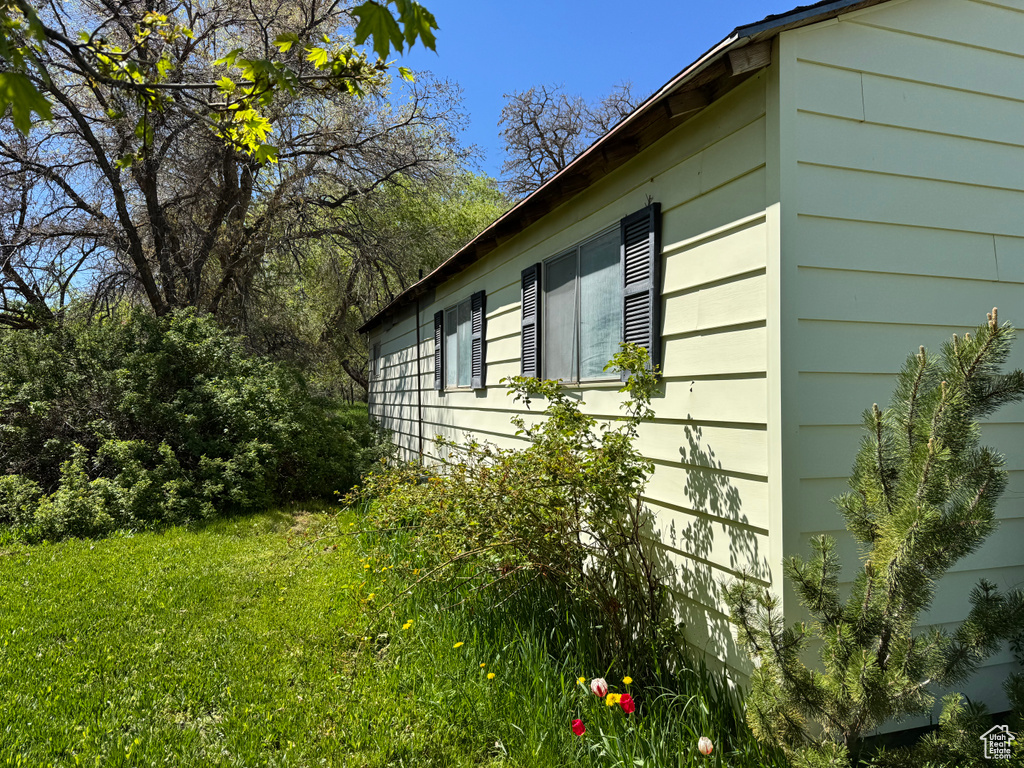 View of property exterior with a yard