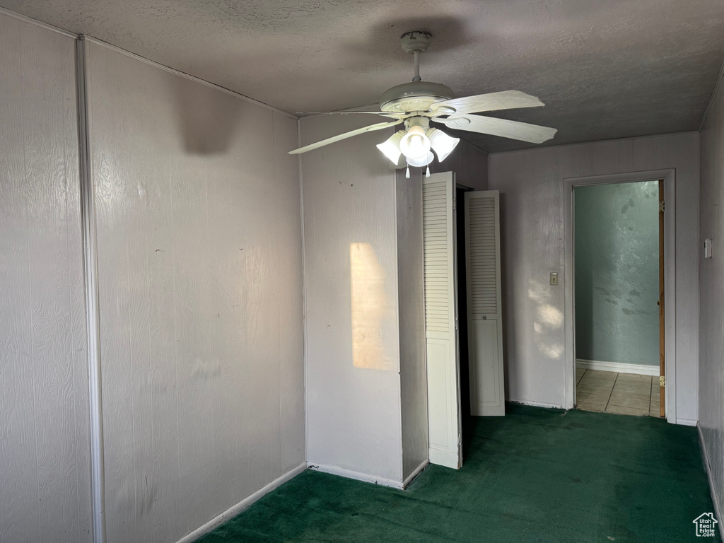 Spare room featuring a ceiling fan, a textured ceiling, carpet floors, and baseboards