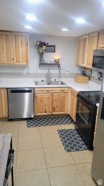 Kitchen featuring appliances with stainless steel finishes, a sink, light brown cabinetry, and recessed lighting