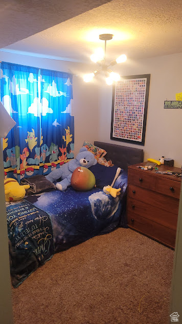 Carpeted bedroom featuring a textured ceiling
