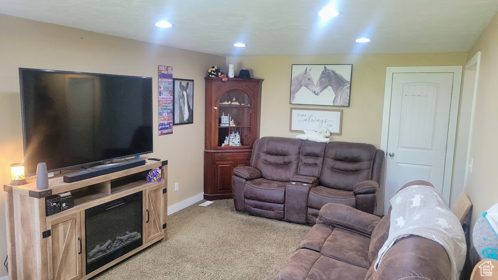 Living room with light colored carpet, recessed lighting, and baseboards