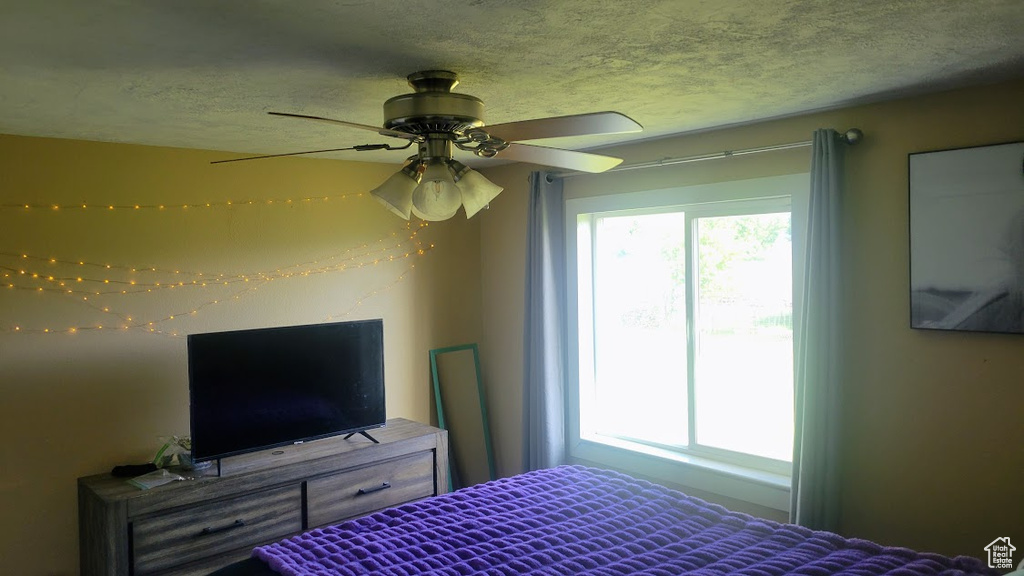 Bedroom with a textured ceiling and ceiling fan