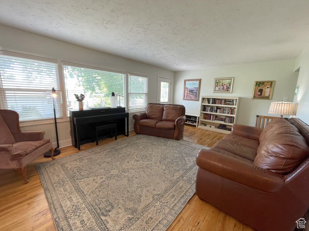 Living area featuring a textured ceiling and light wood-style floors