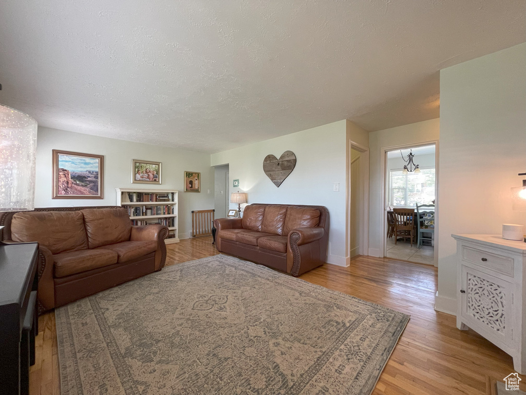 Living area featuring light wood-style floors, baseboards, and a textured ceiling