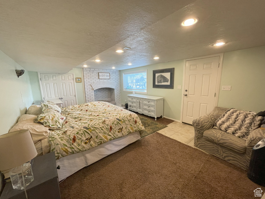 Tiled bedroom featuring a textured ceiling and recessed lighting