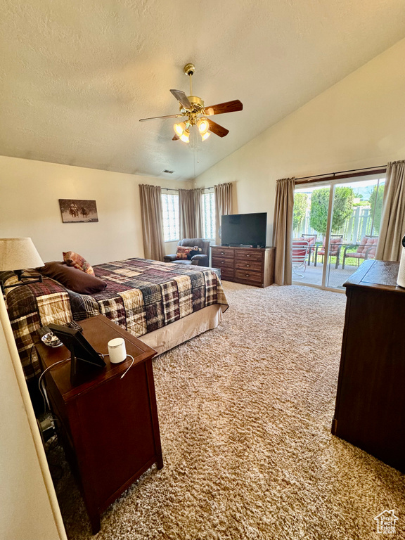 Carpeted bedroom featuring access to exterior, vaulted ceiling, a textured ceiling, and ceiling fan