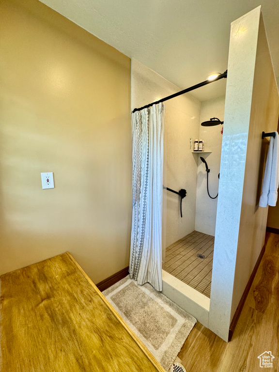 Full bathroom with a stall shower and wood finished floors
