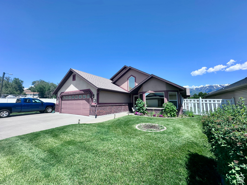 Single story home with brick siding, an attached garage, driveway, and stucco siding