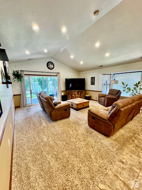 Living area with vaulted ceiling, a textured ceiling, carpet, and recessed lighting
